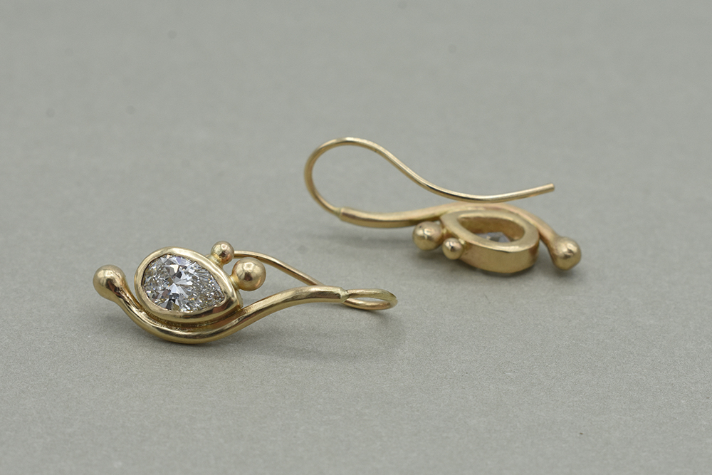 A closeup of gold and diamond earrings