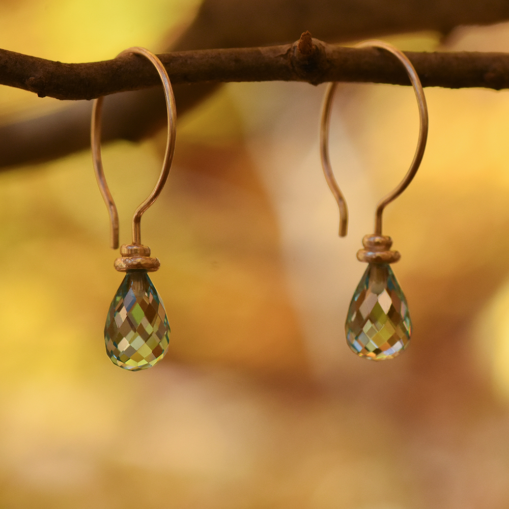 A closeup photo of drop earrings made with topaz stones