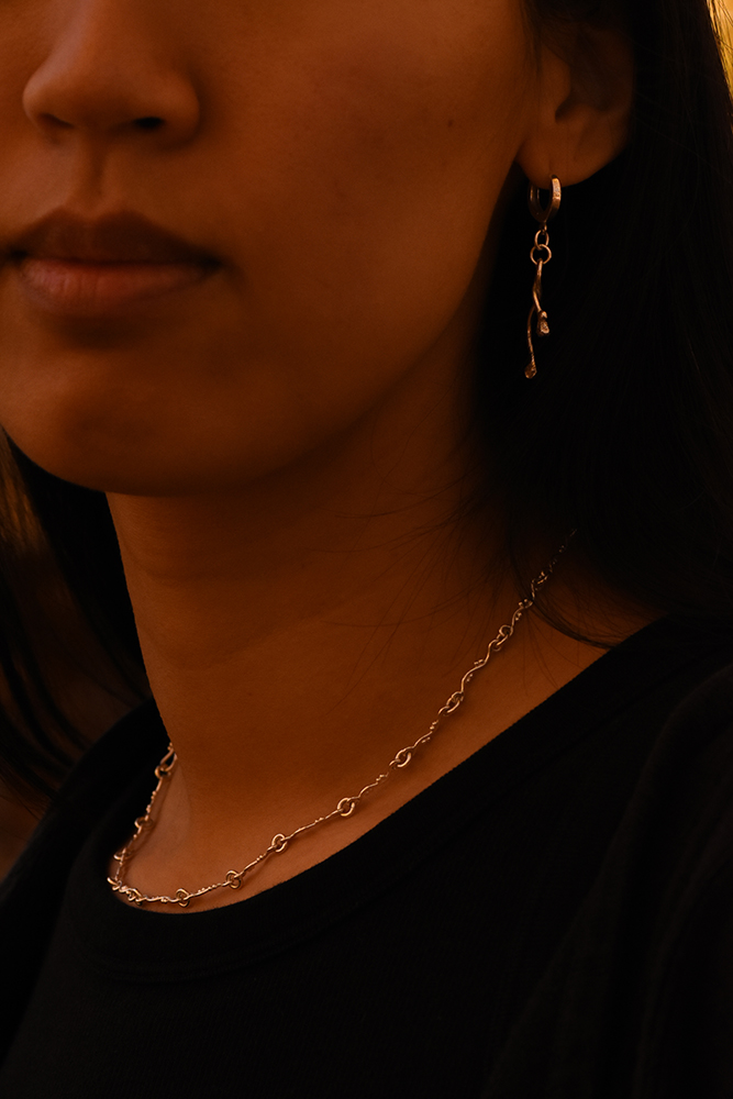 A photo of a necklace and earrings from the Wisp collection