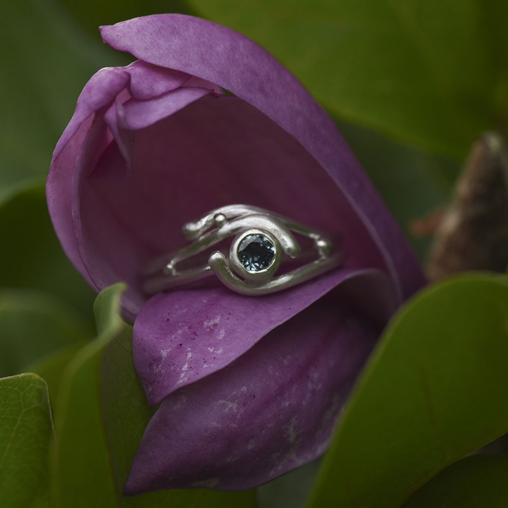 A closeup of sterling silver ring with a Montana sapphire gem